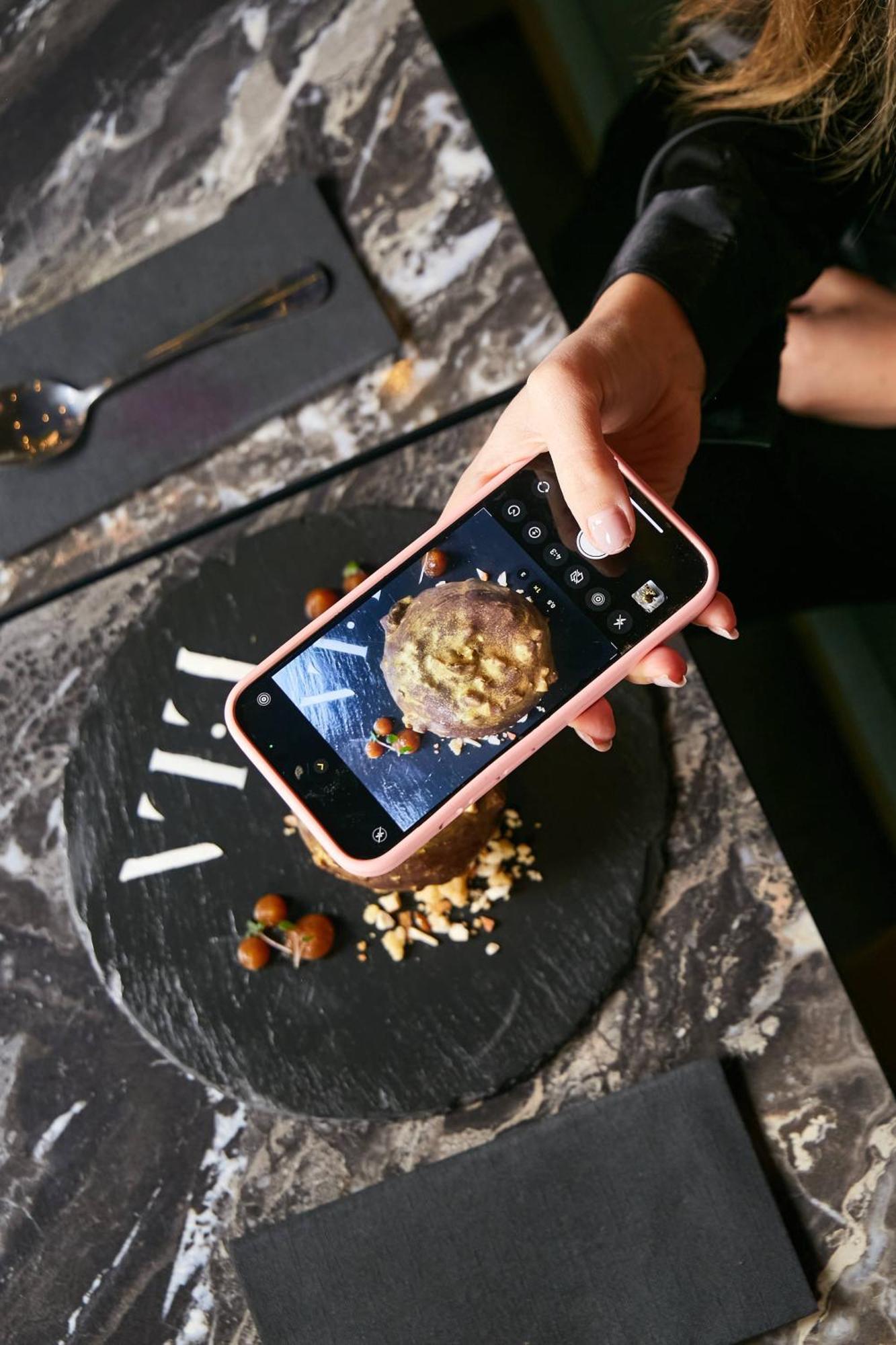 Pullman Santiago El Bosque Hotel ภายนอก รูปภาพ A smartphone being used to take a photograph of a food item